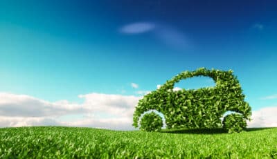 Silhouette d'une voiture formée de feuillage vert sur un fond de ciel bleu.