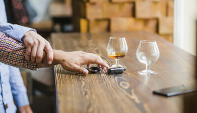 Prévention de l’alcool au volant : une main empêche une personne alcoolisée de reprendre le volant