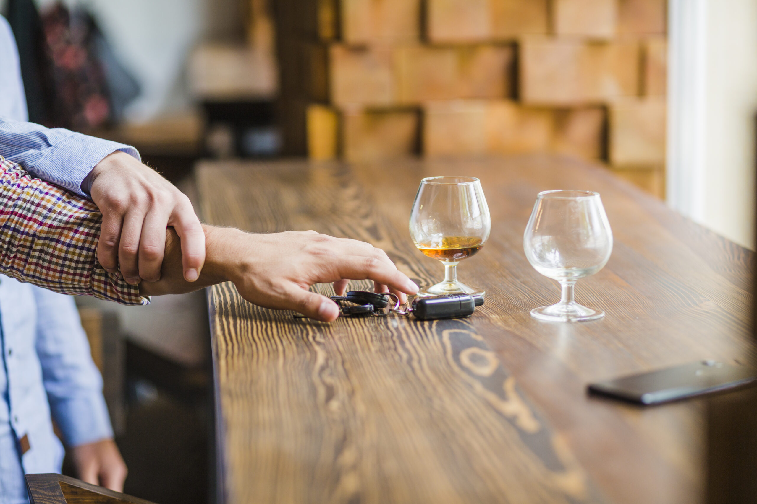 Prévention de l’alcool au volant : une main empêche une personne alcoolisée de reprendre le volant