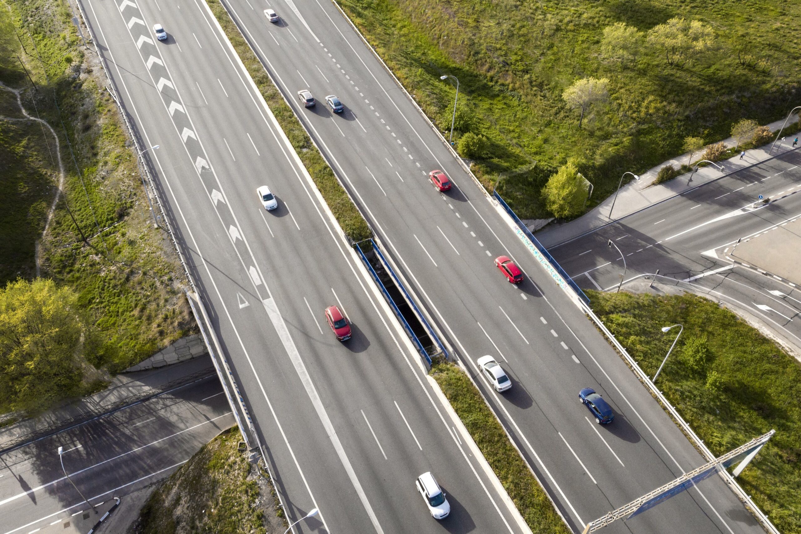 Vue aérienne d’une autoroute avec plusieurs voitures circulant sur différentes voies, illustrant le respect des distances de sécurité entre les véhicules.
