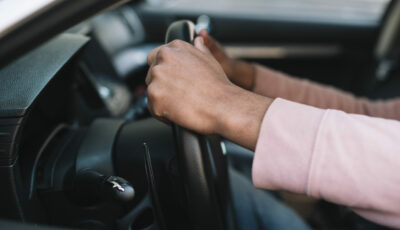 Conducteur tenant fermement le volant d'une voiture moderne, prêt à prendre la route, illustrant les équipements de sécurité obligatoires en 2025.