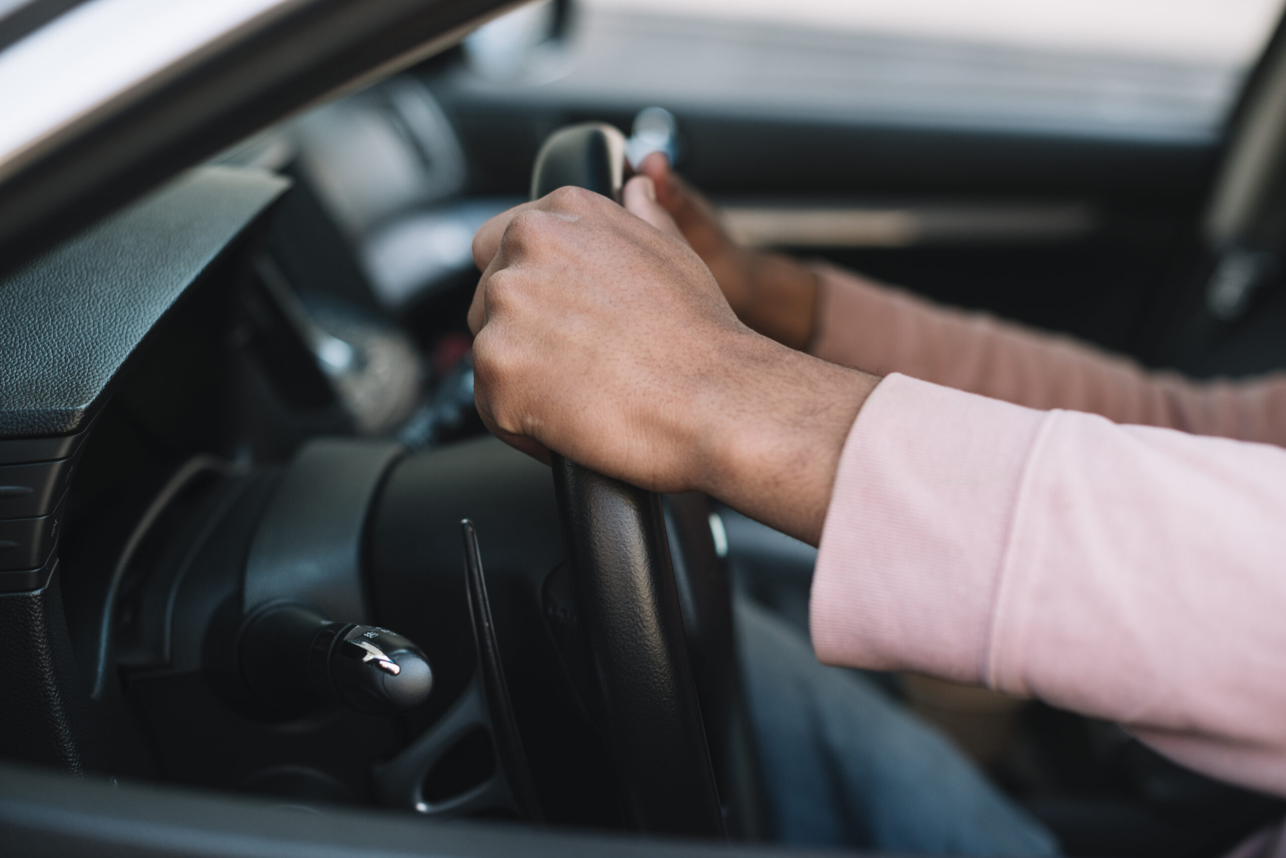 Conducteur tenant fermement le volant d'une voiture moderne, prêt à prendre la route, illustrant les équipements de sécurité obligatoires en 2025.