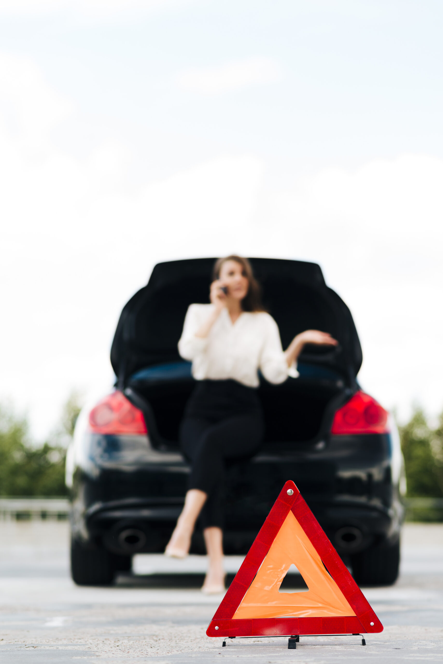 Femme, téléphone, voiture en panne, triangle de signalisation. Équipements obligatoires voiture.