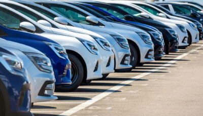 Autonomie véhicule électrique: Rangée de voitures neuves, bleues, blanches et noires.