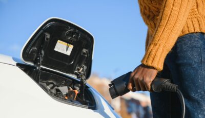 Recharge d’un véhicule électrique : un conducteur connecte le câble à la borne pour améliorer l’autonomie et la performance de la batterie.