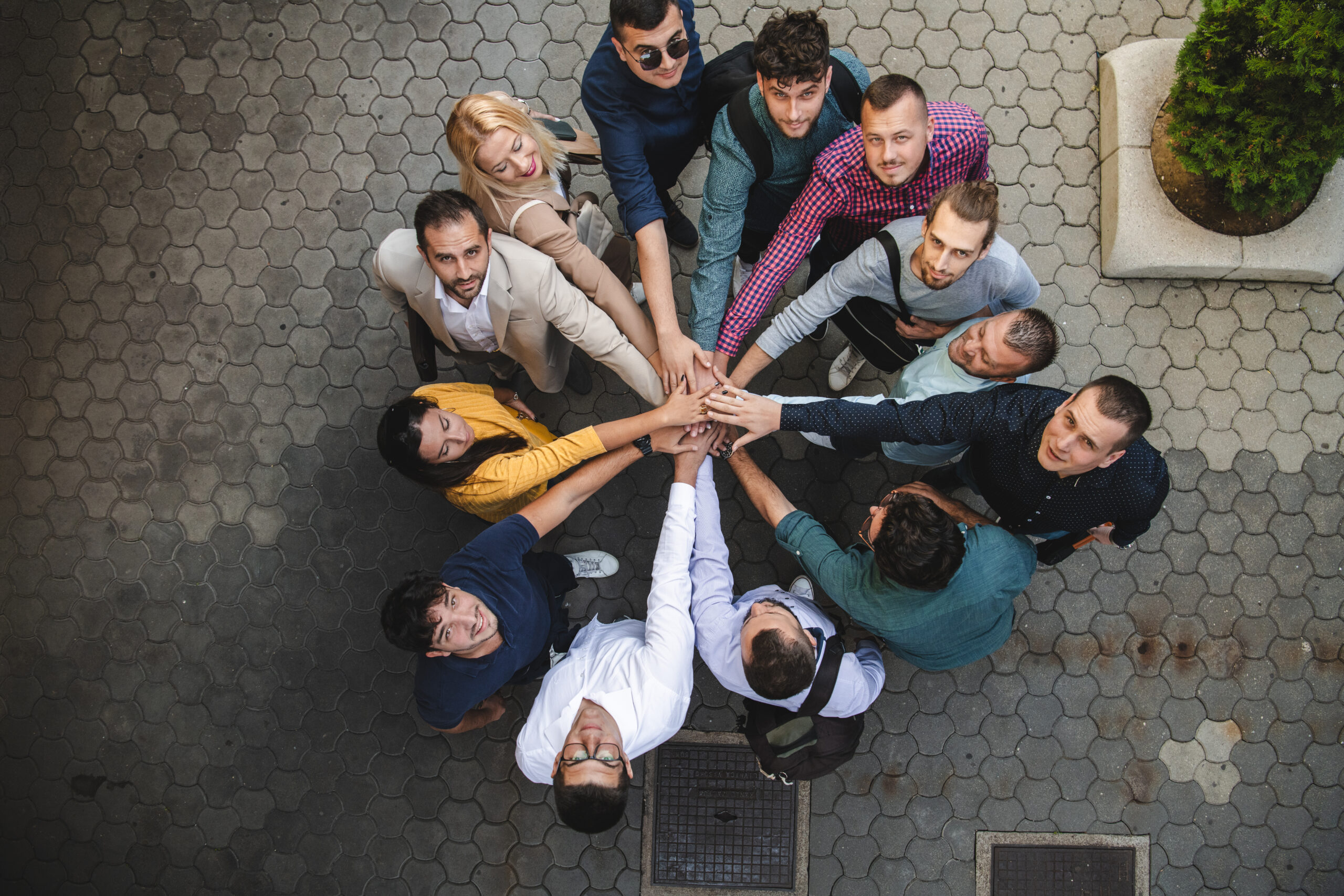 Groupe de collaborateurs réunis en cercle, mains superposées, illustrant la cohésion d’équipe lors d’une Journée Sécurité. 